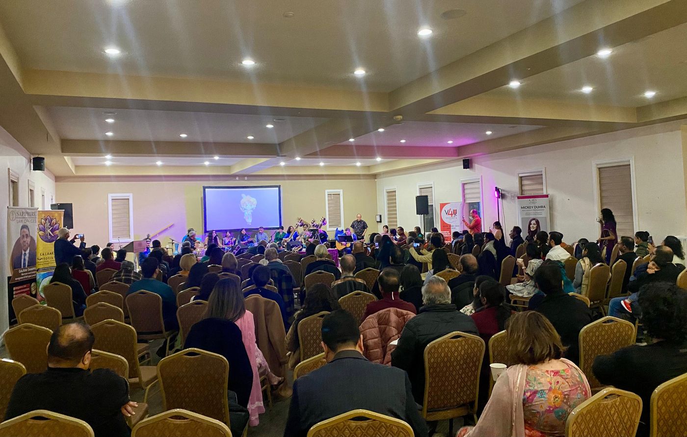 A packed hall of audience members facing the stage